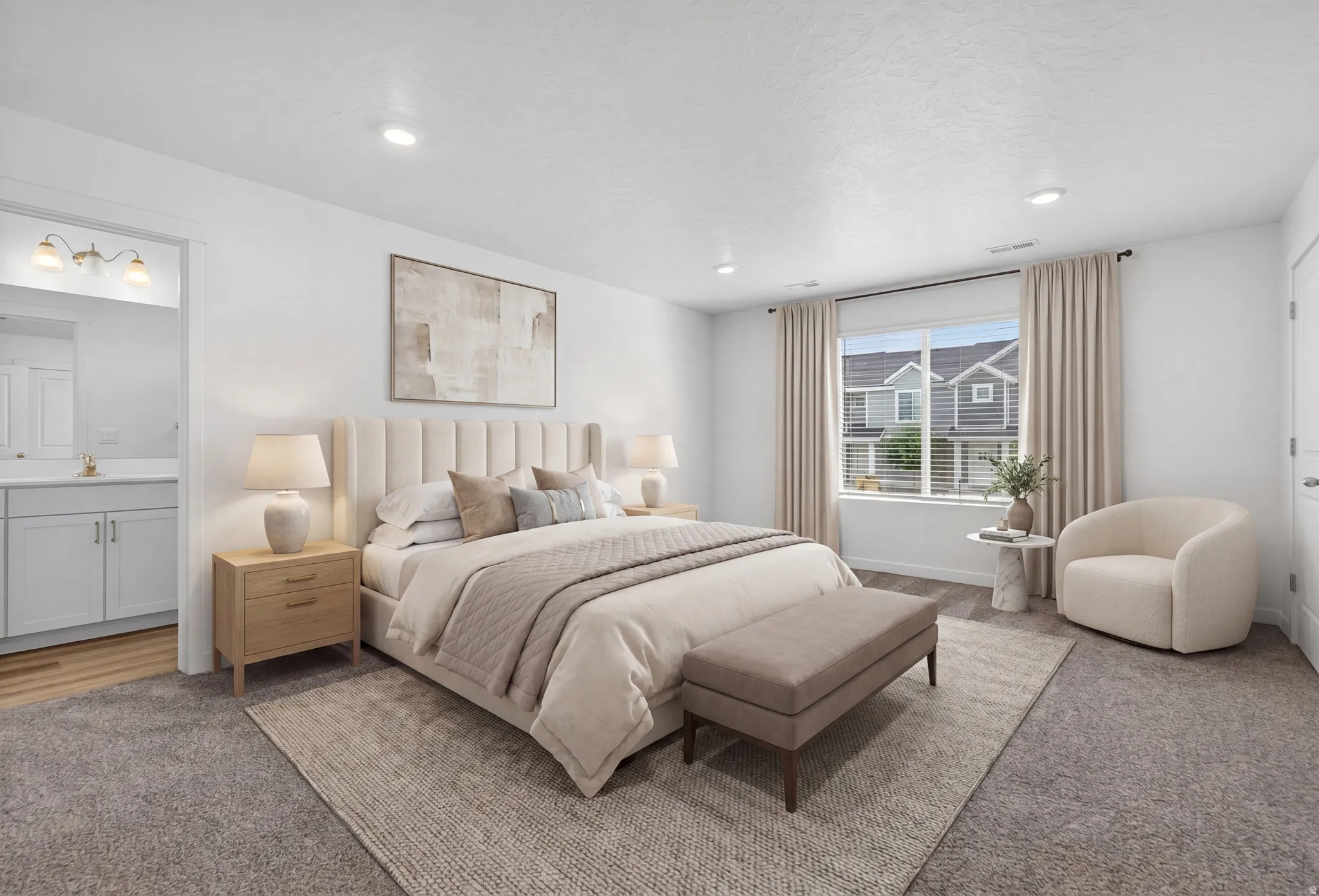 Spacious room featuring neutral carpeting, recessed lighting, a large window with blinds, and an entryway to an adjacent bathroom with a light wood-finish vanity and wall-mounted lighting