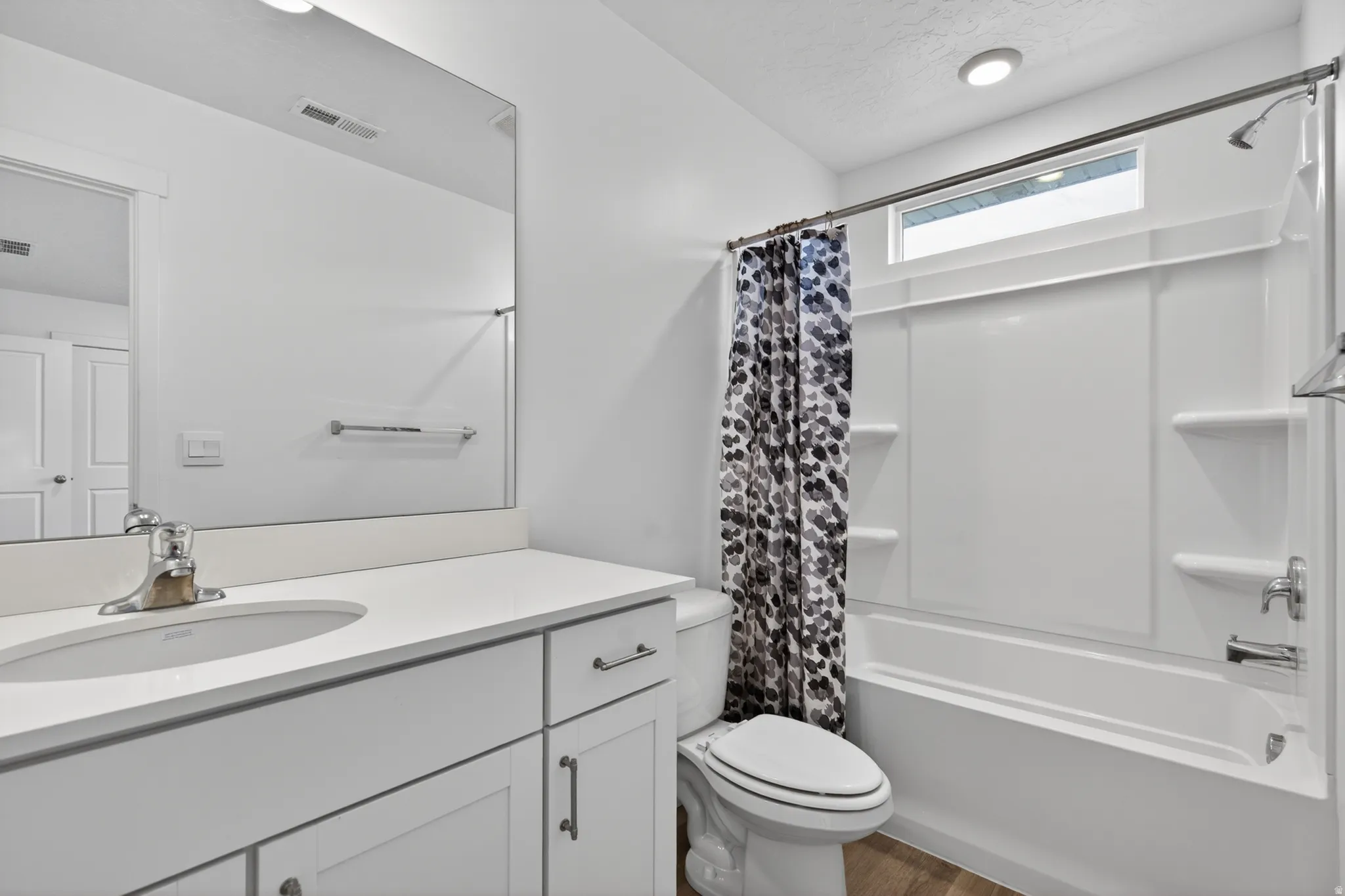 Bathroom featuring a white vanity with an integrated sink, polished chrome faucet, and white countertop