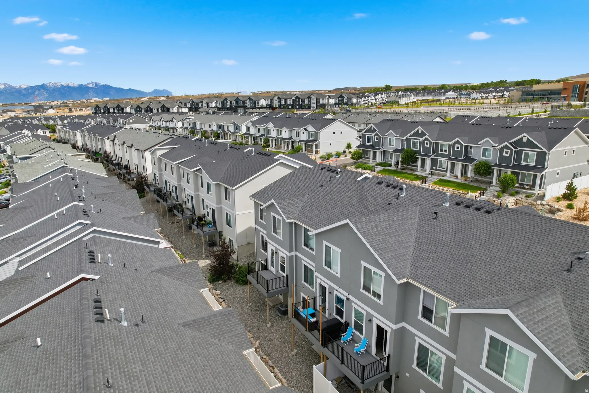 Development of multi-story townhomes featuring contemporary facades and dark shingle roofing