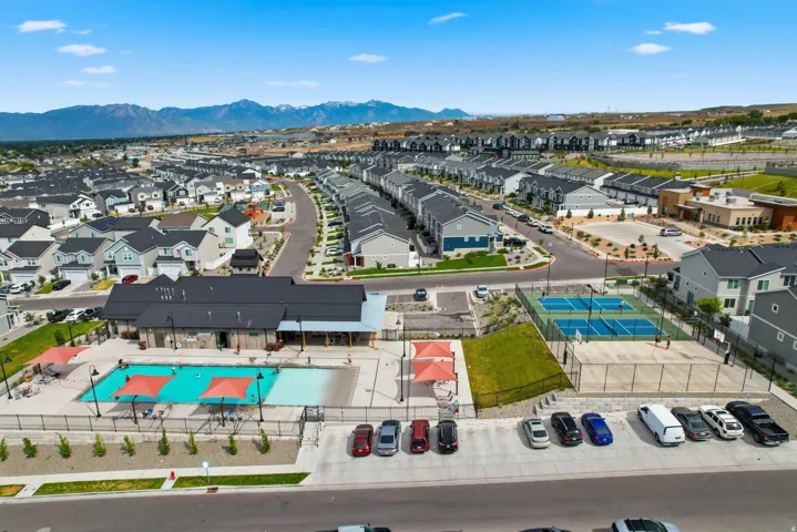 Community amenities featuring a swimming pool, clubhouse, multiple sports courts, and mountain backdrop
