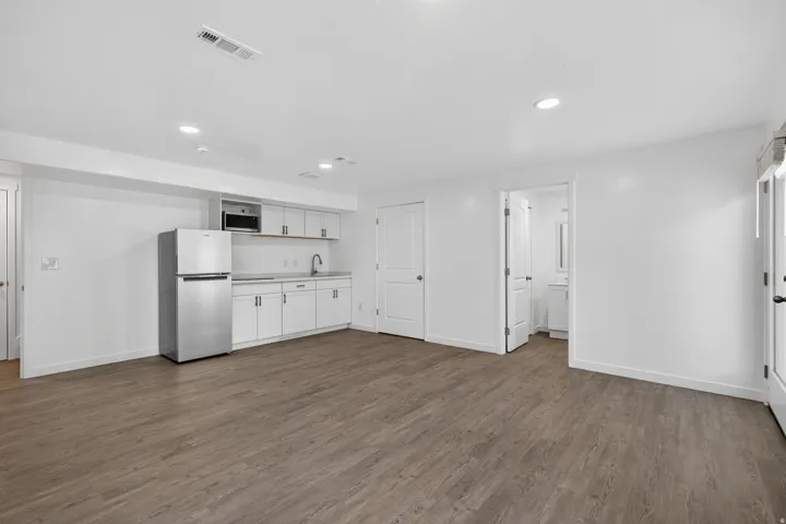 Open-concept room featuring wood-finish flooring, recessed lighting, and a kitchen area