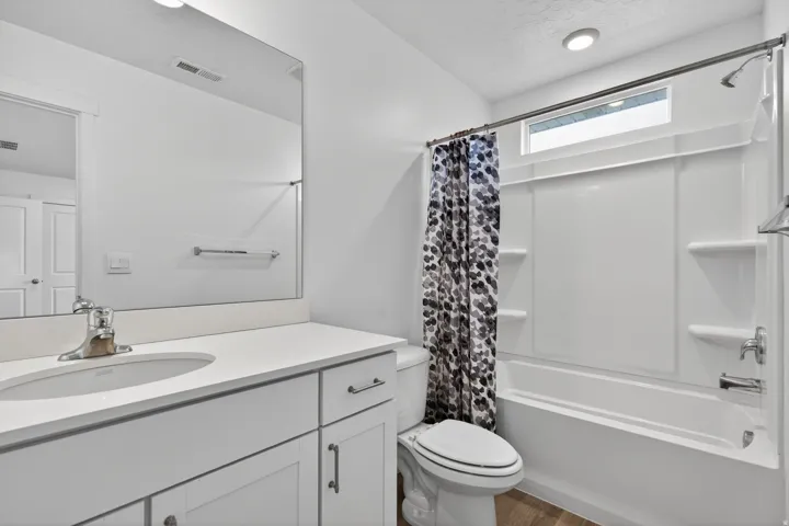 Bathroom featuring a white vanity with an integrated sink, polished chrome faucet, and white countertop