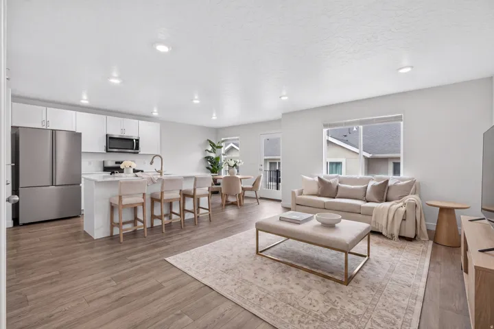 Open-concept living area featuring wood-finish flooring, recessed lighting, and a neutral color palette