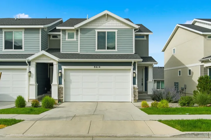 Contemporary residential facade featuring light blue horizontal siding and dark blue trim