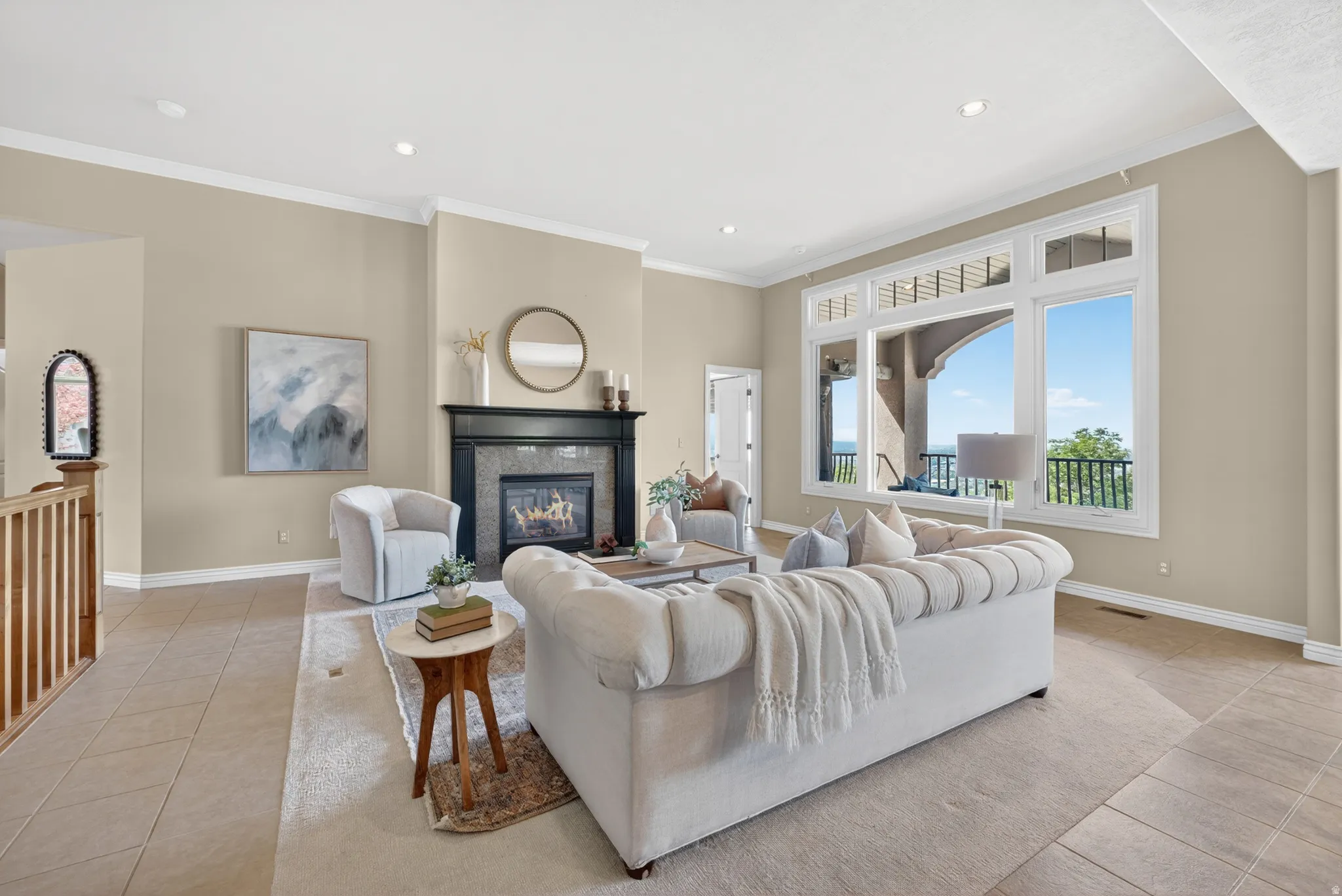 Living area featuring a contemporary fireplace with a dark mantel, large picture windows, recessed lighting, and crown molding