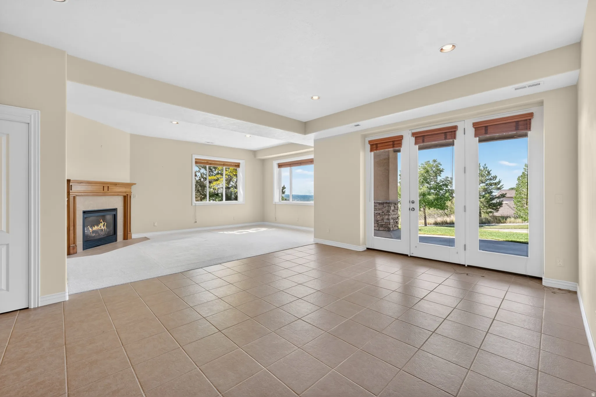 Spacious  walkout family room featuring large format tile flooring and an integrated carpeted area
