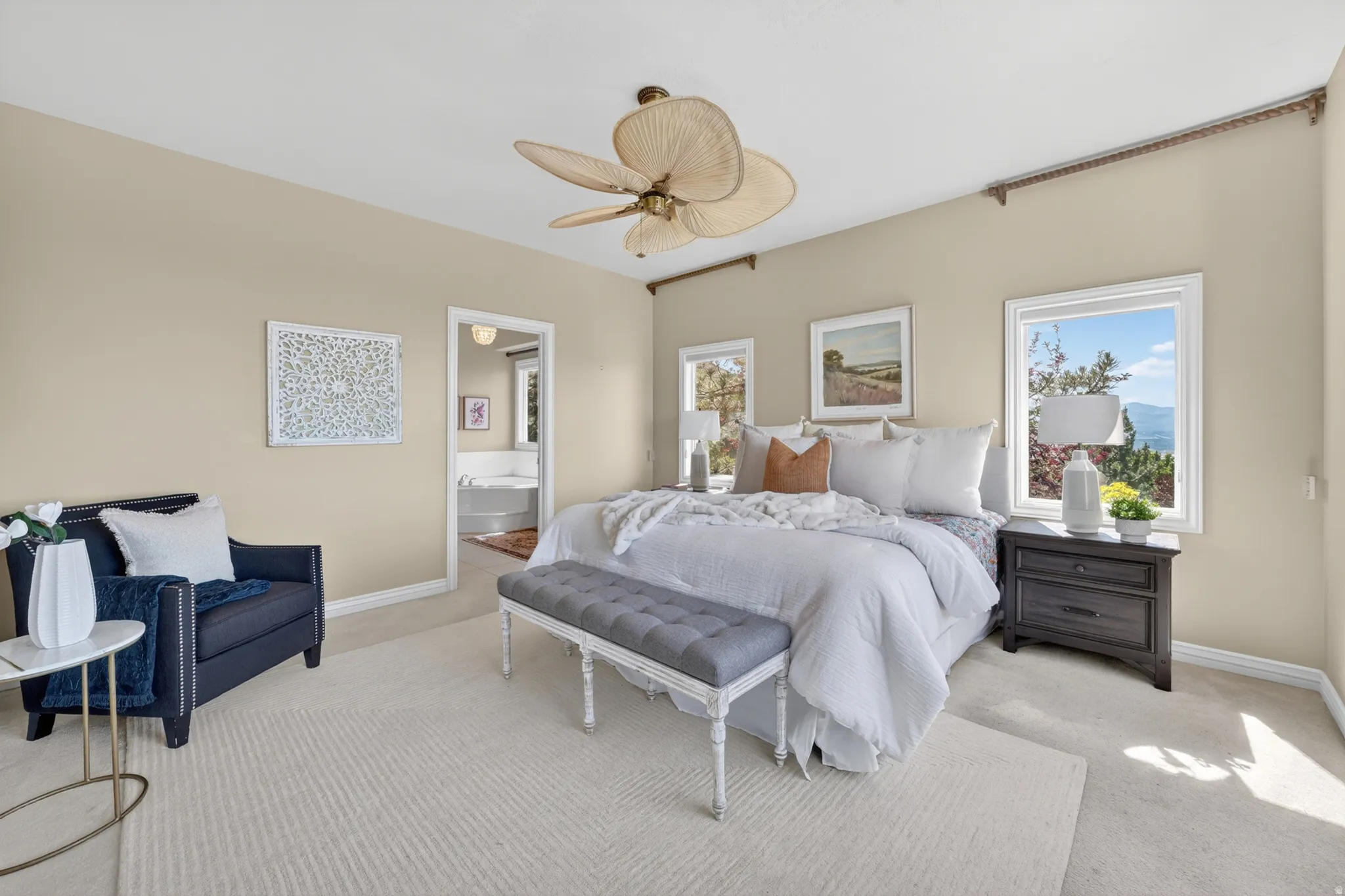 Primary bedroom featuring light-colored carpeting, multiple windows providing natural light