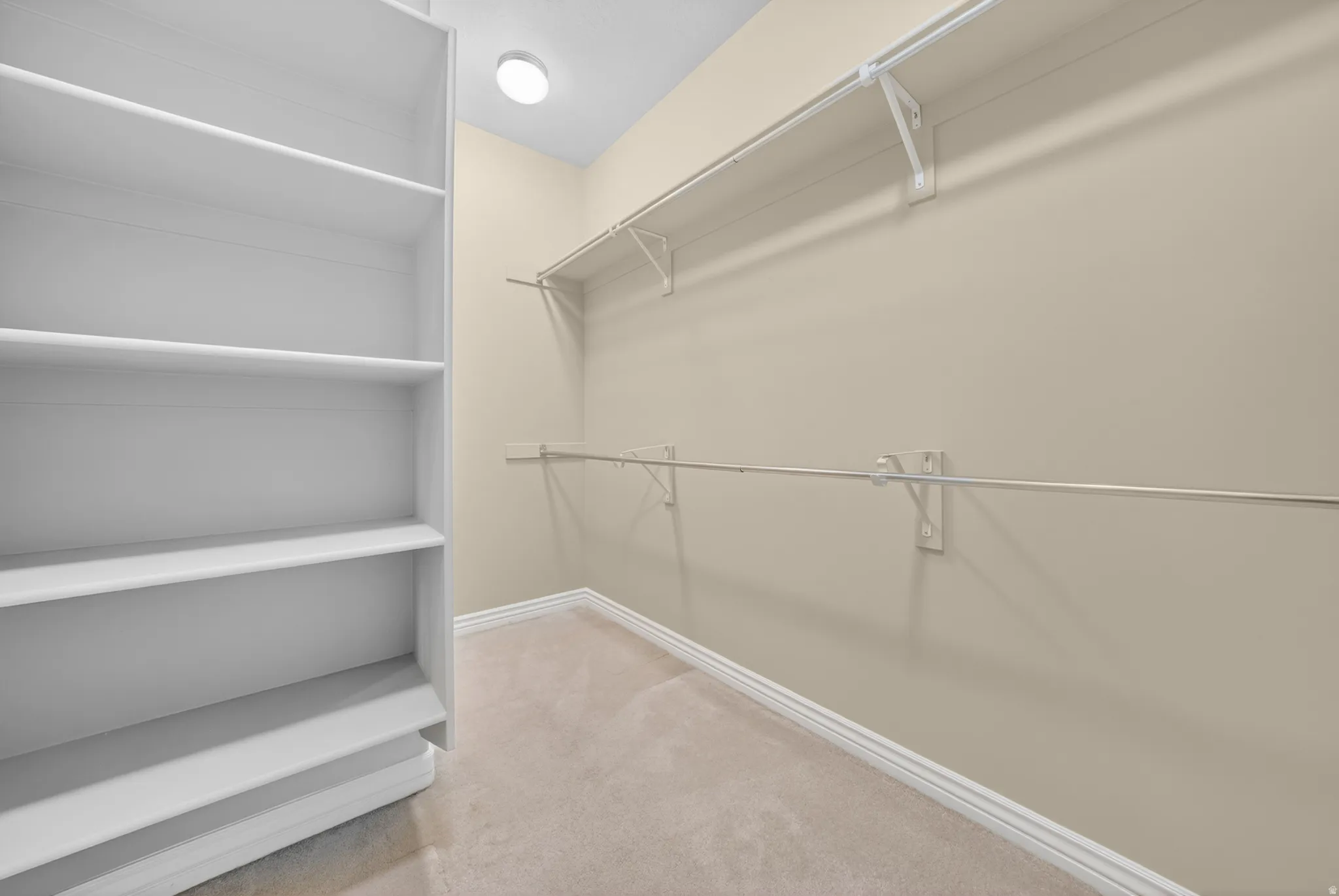 Walk-in closet featuring built-in shelving, wire racks, and hanging rods