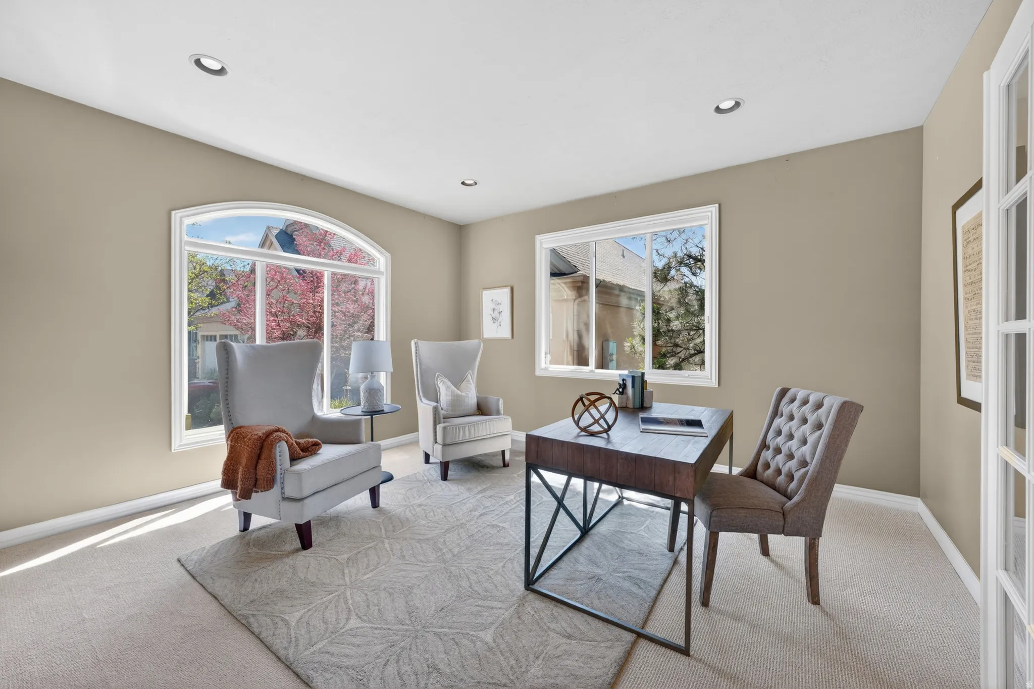 Spacious room featuring a prominent arched window, recessed lighting, and neutral wall tones