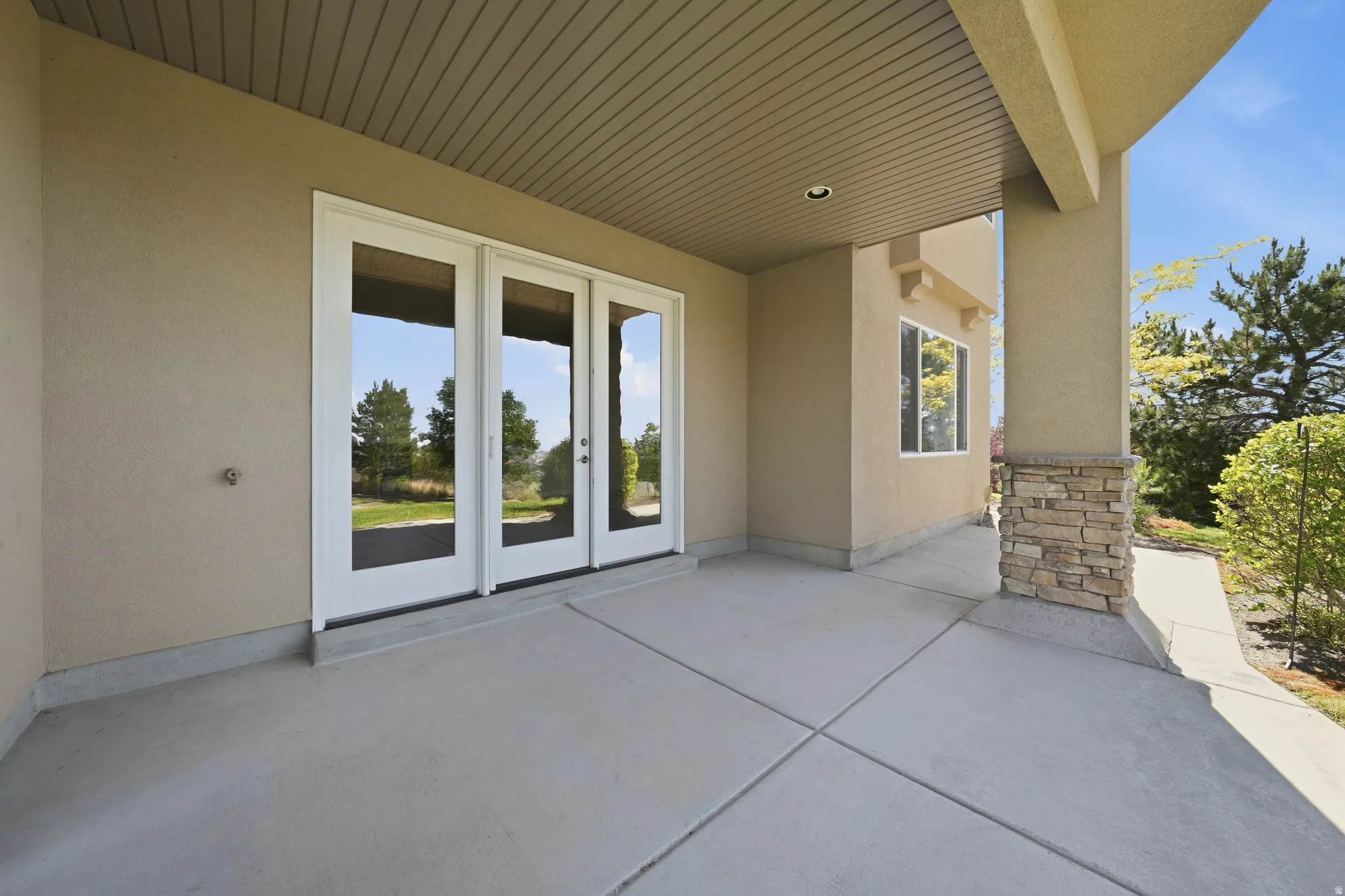 Covered patio featuring multiple glass-paneled doors with mountain views