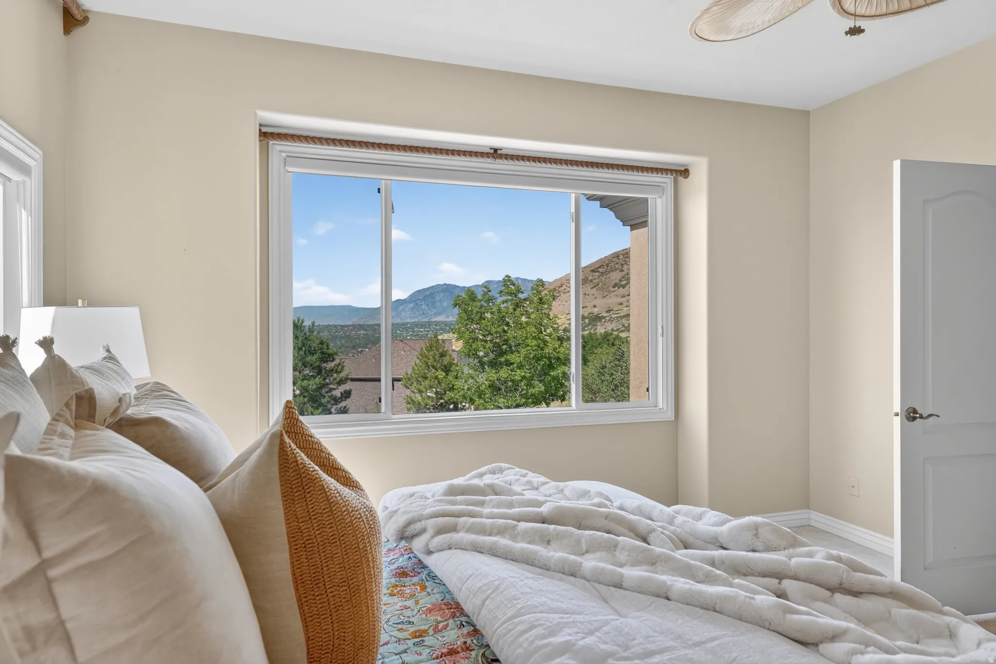 Large window framing a mountainous landscape with mature trees