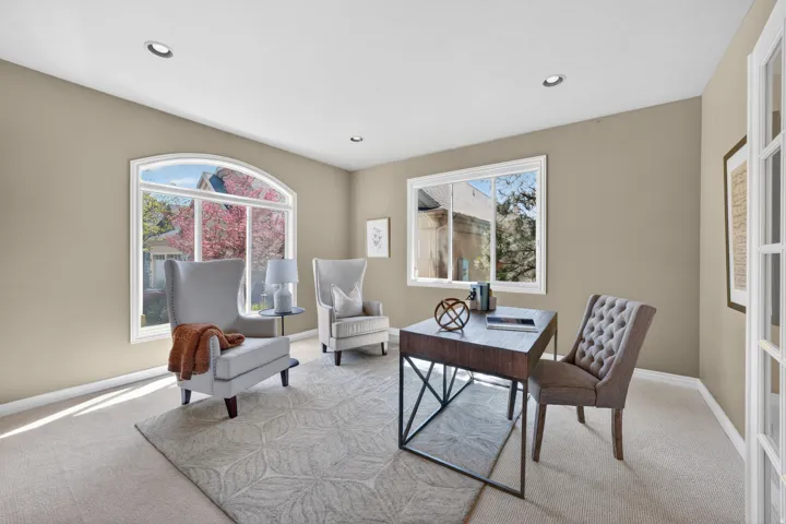 Spacious room featuring a prominent arched window, recessed lighting, and neutral wall tones