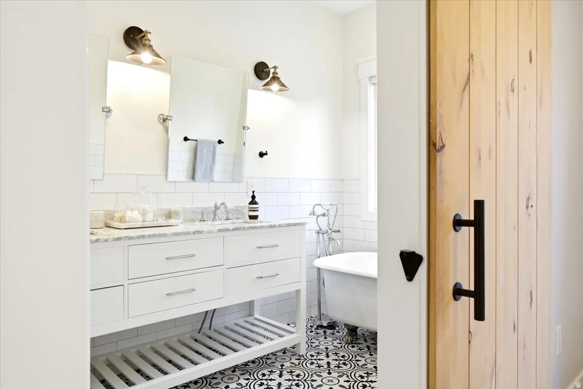 Bathroom featuring a double vanity with white cabinetry and a light-toned countertop