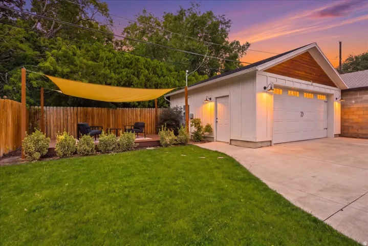 Detached garage with a wood-finish gable accent, featuring a two-car garage door and separate pedestrian entry