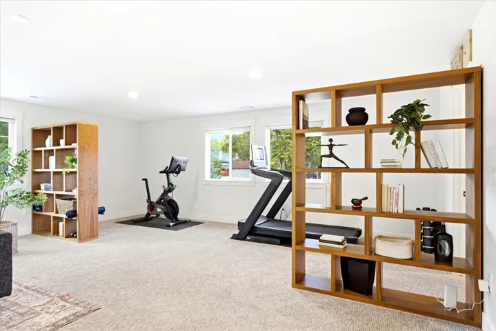 Spacious room featuring light-colored carpeting, recessed lighting, and multiple windows