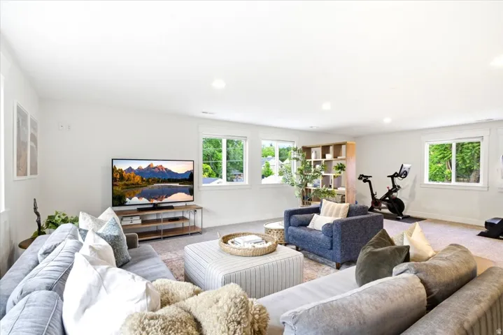 Spacious interior room featuring light-toned walls, recessed lighting, and multiple windows with white trim