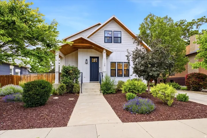 Modern farmhouse exterior with white siding and a dark blue entry door