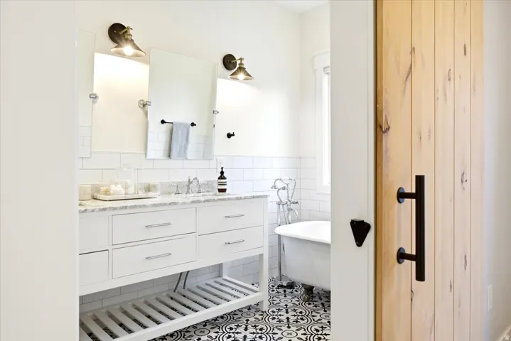 Bathroom featuring a double vanity with white cabinetry and a light-toned countertop