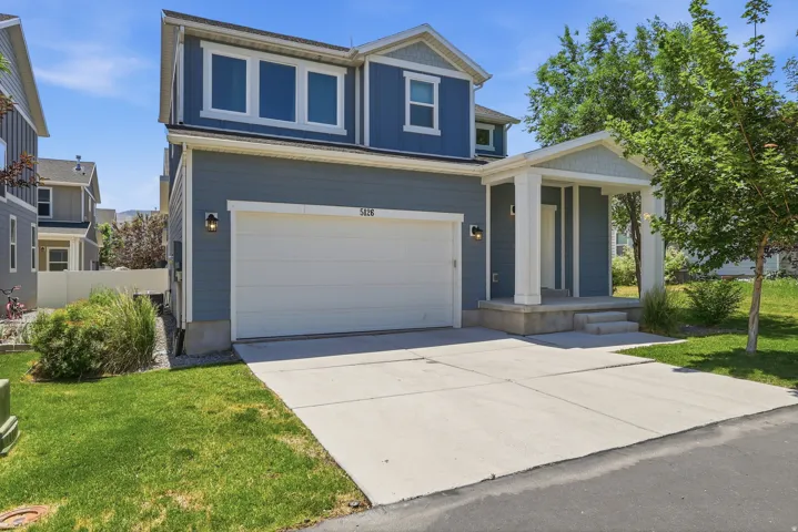 Contemporary two-story residence with a covered front porch featuring white columns and a gray paneled door