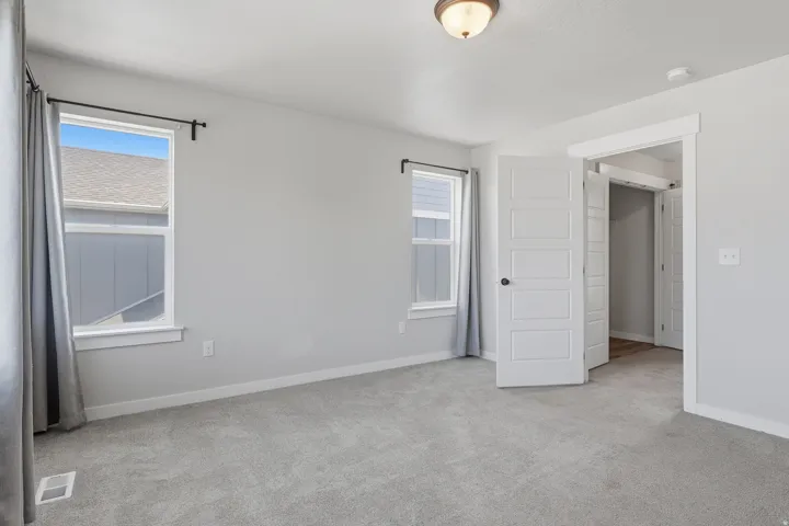 Bedroom featuring neutral gray wall paint and coordinating gray carpet