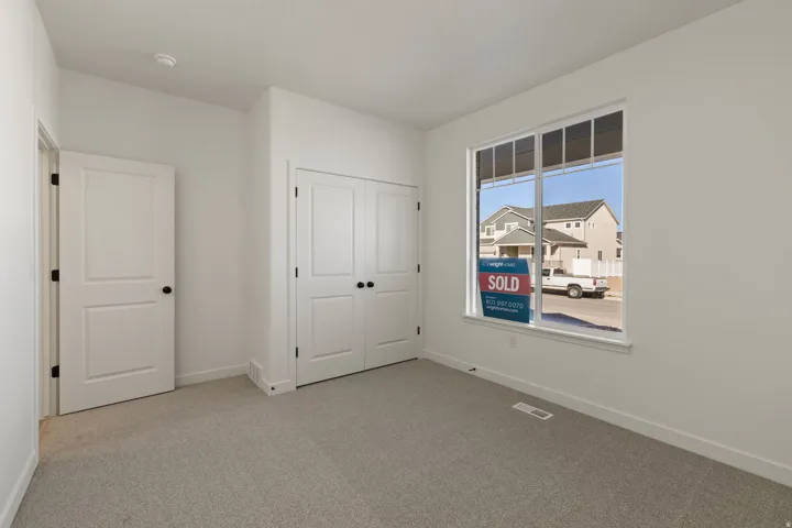 Neutral-toned carpeting paired with white walls, baseboards, and trim