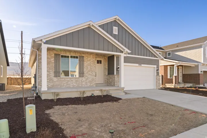 Single-story residence featuring a light-colored brick facade, contrasting gray siding, and a white garage door