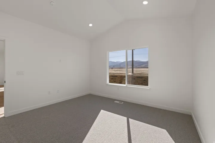 Room featuring a vaulted ceiling and recessed lighting