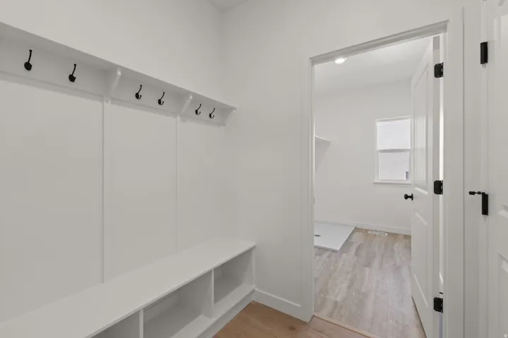 Built-in mudroom bench with cubby storage and matte black hooks