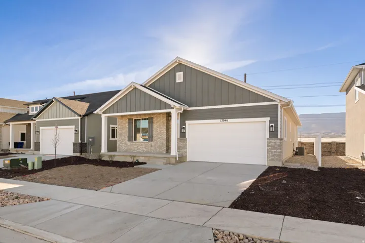 Contemporary ranch-style residence featuring a combination of horizontal and vertical siding, stone veneer accents, and a covered porch
