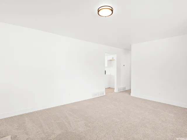 Neutral tone carpet flooring and white painted walls