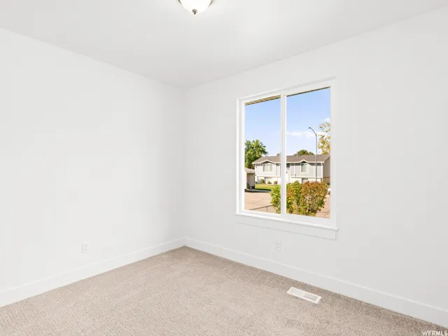 Neutral-toned carpet flooring, white painted walls, and white trim