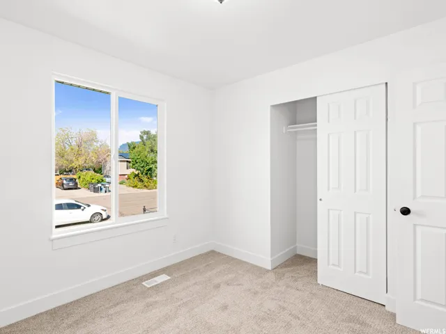 Neutral-toned carpeting extends throughout this room, complemented by white walls and trim