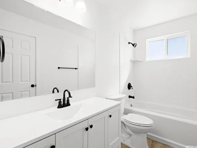 Bathroom featuring a white vanity with integrated sink, matte black faucet, and white countertop