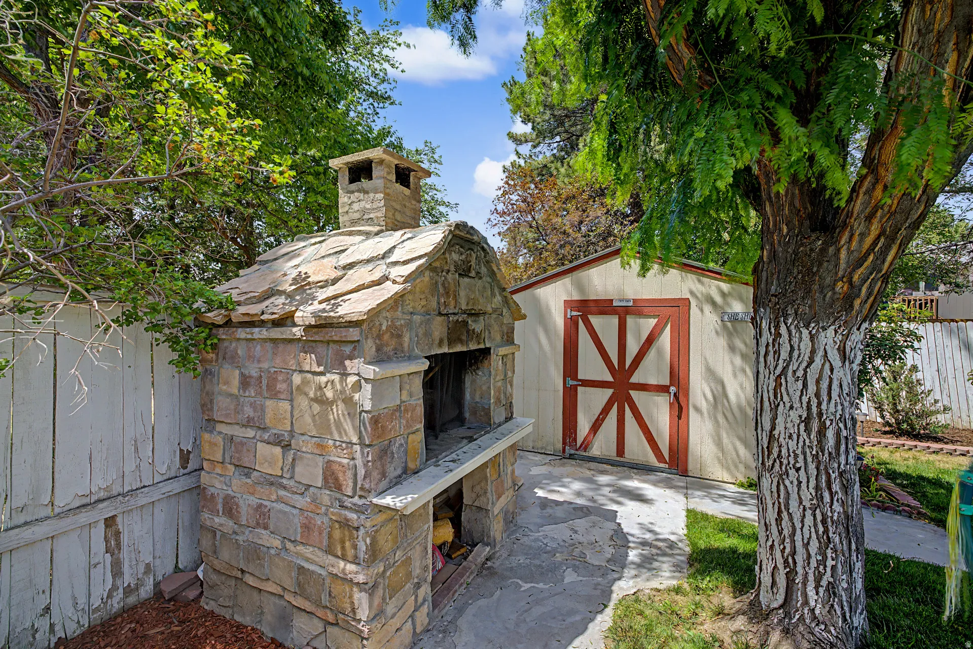 Stone outdoor oven with a natural stone slab roof and integrated chimney
