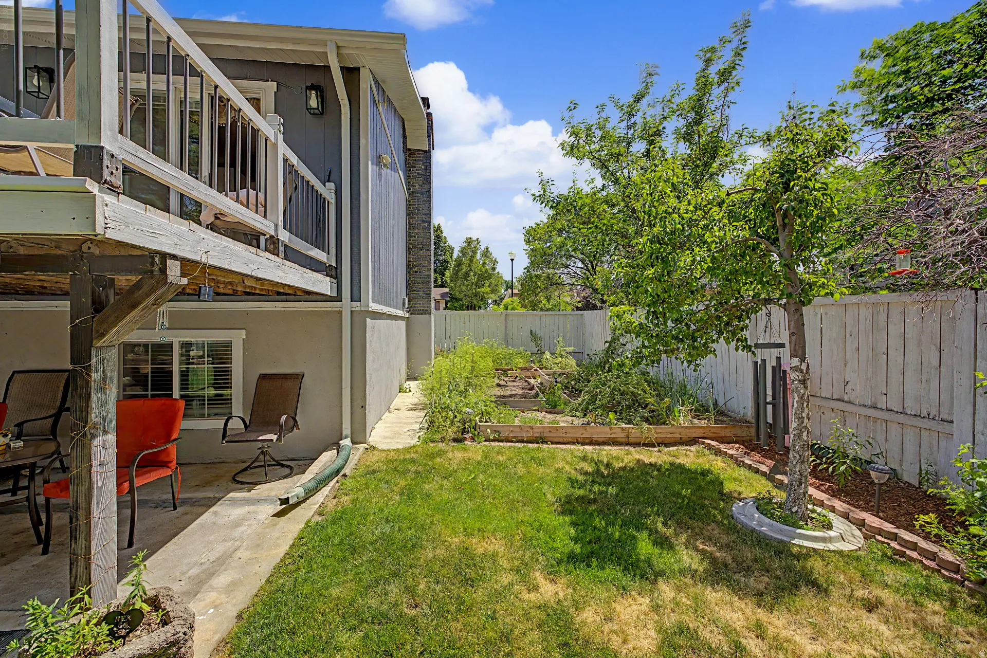 Private backyard featuring a concrete patio and a raised wooden deck