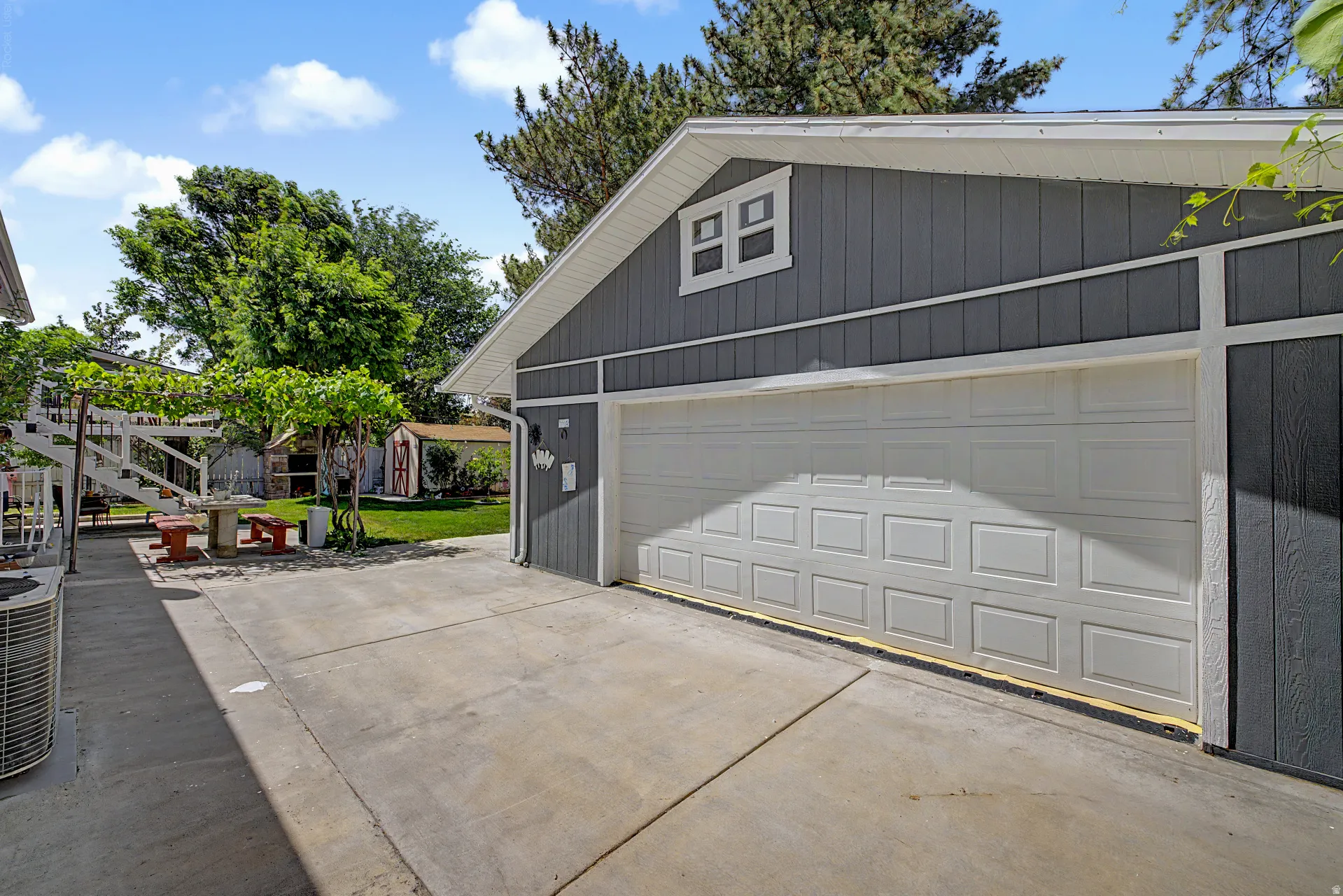 Detached garage featuring board-and-batten siding and a white paneled door