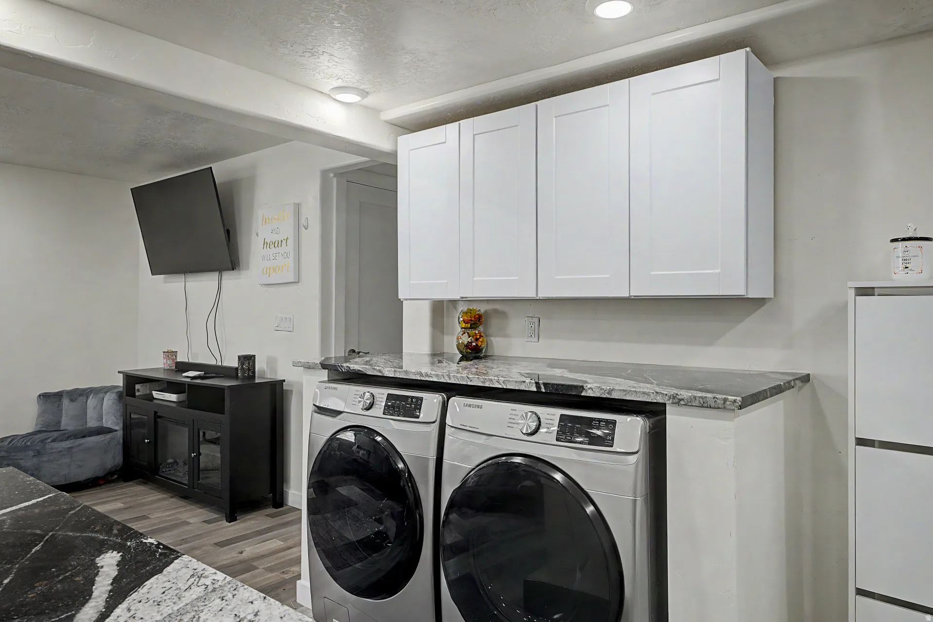 Dedicated laundry area featuring a granite-style countertop, white shaker-style cabinetry, and recessed lighting