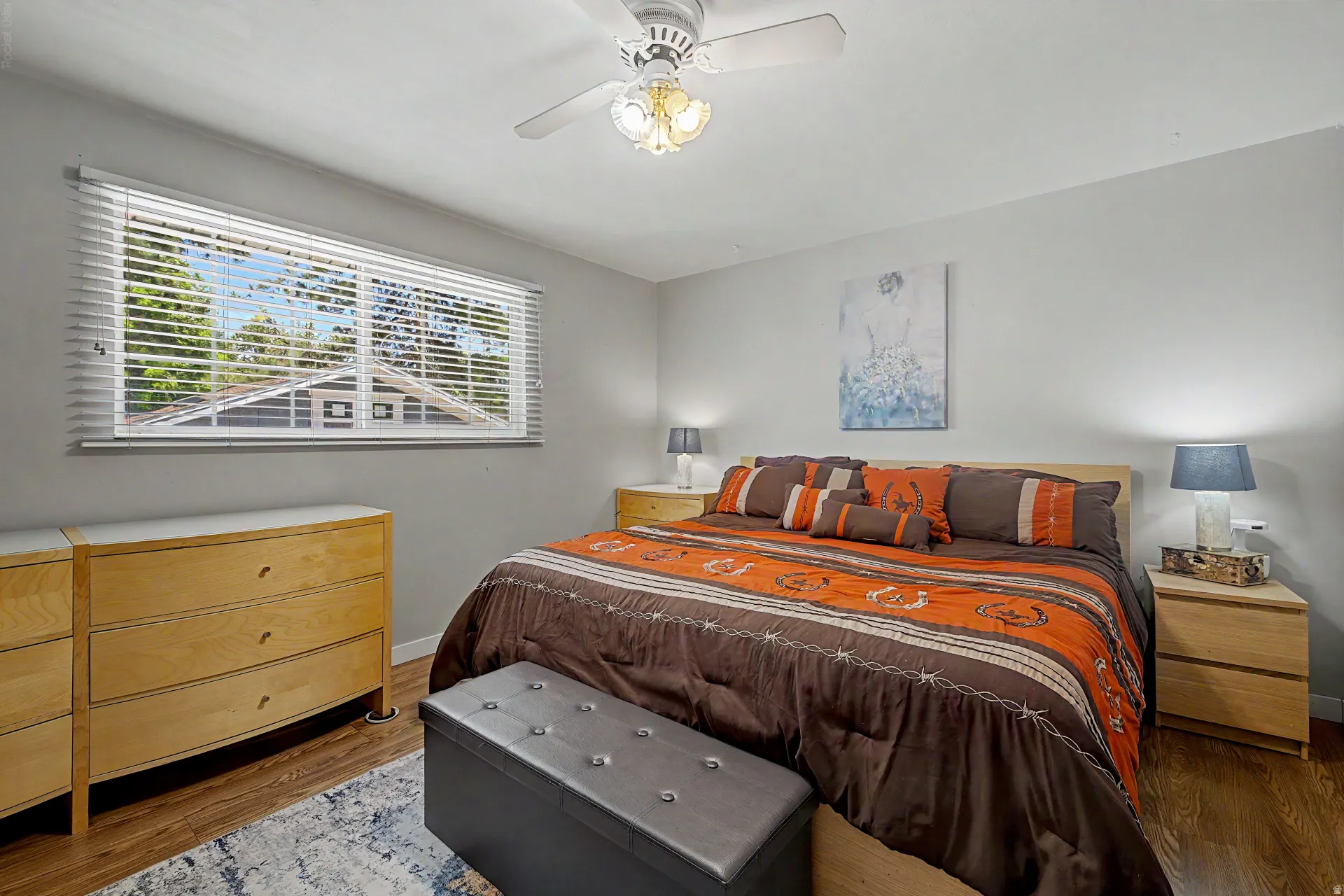 Bedroom featuring wood-finish flooring, a ceiling fan with integrated lighting, and a horizontal window with blinds