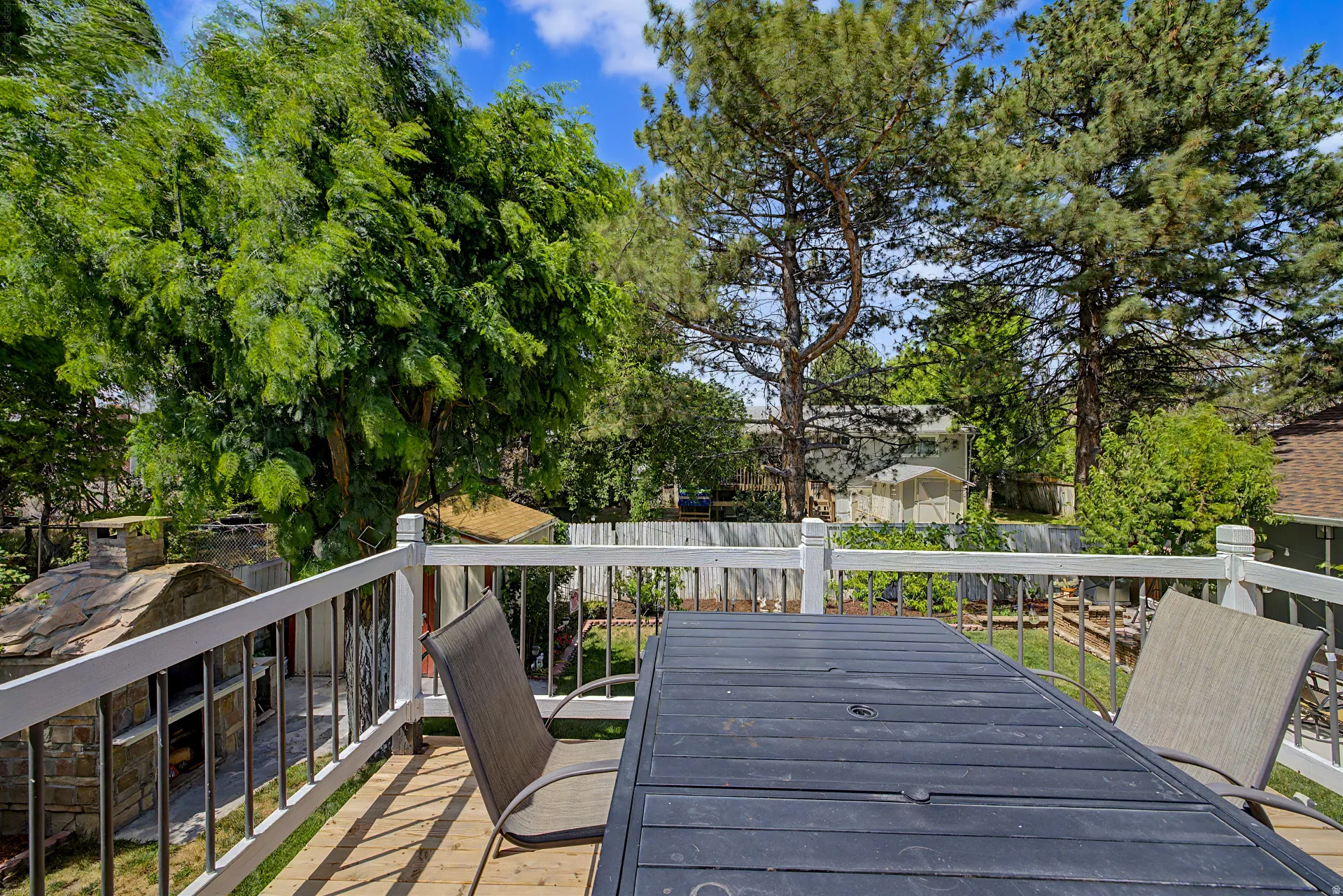 Wood-finish deck featuring white railings with black balusters