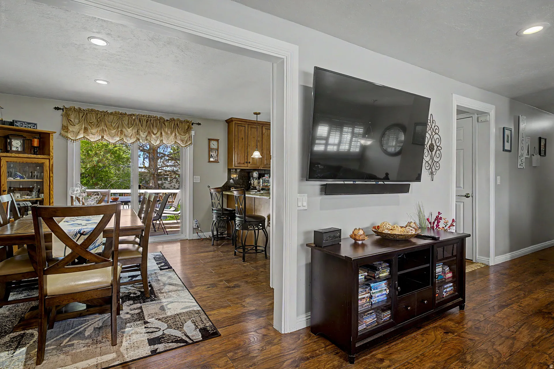 Expansive open-concept living area featuring wood-finish flooring throughout, recessed ceiling lighting, and a neutral wall palette