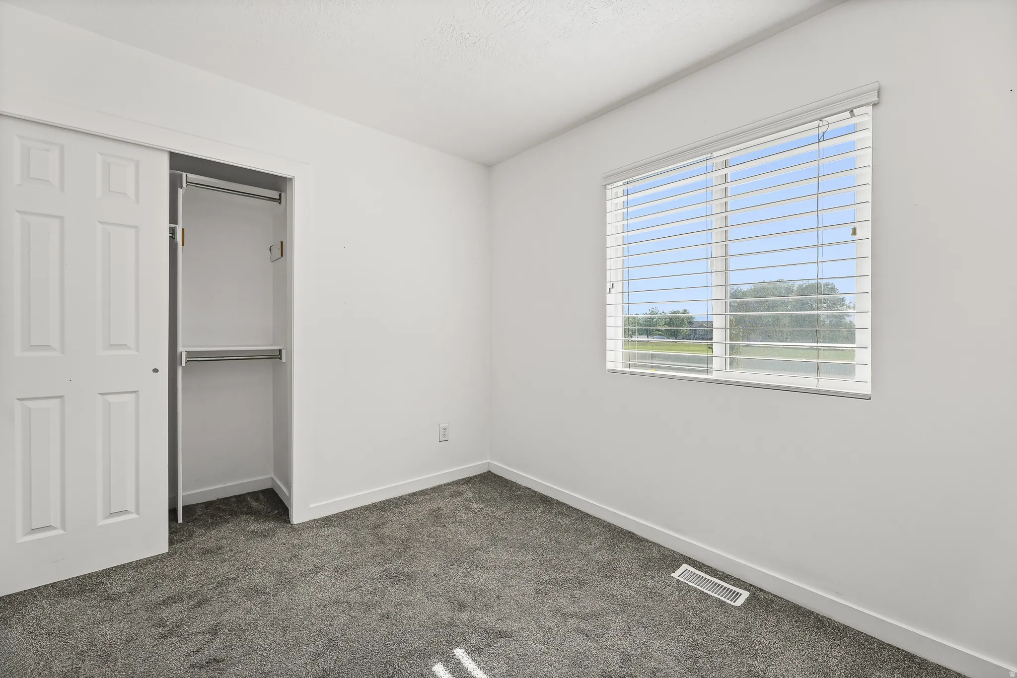 Room with white walls and grey carpet flooring