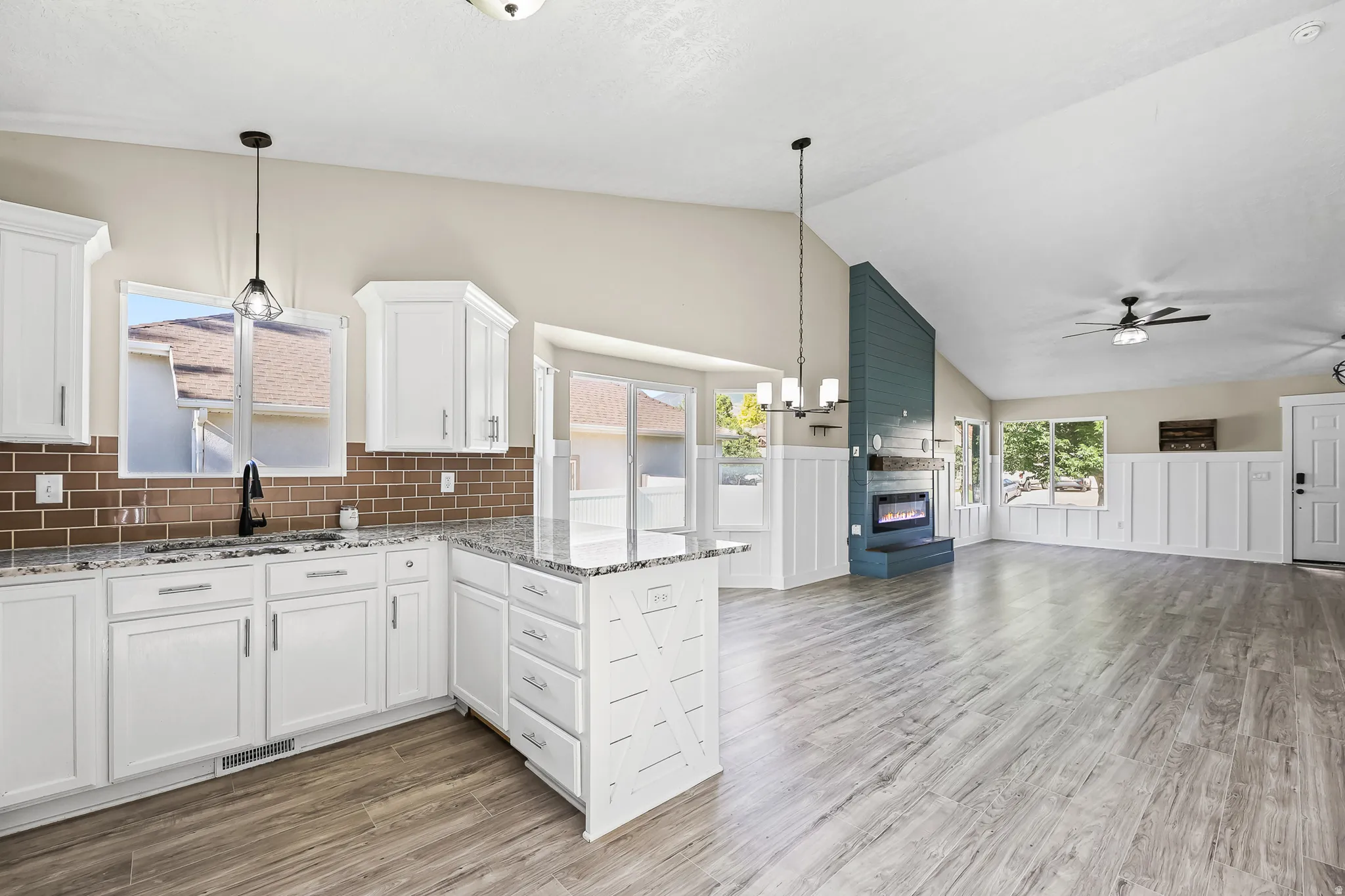 Open-concept living space featuring vaulted ceilings and wood-finish flooring