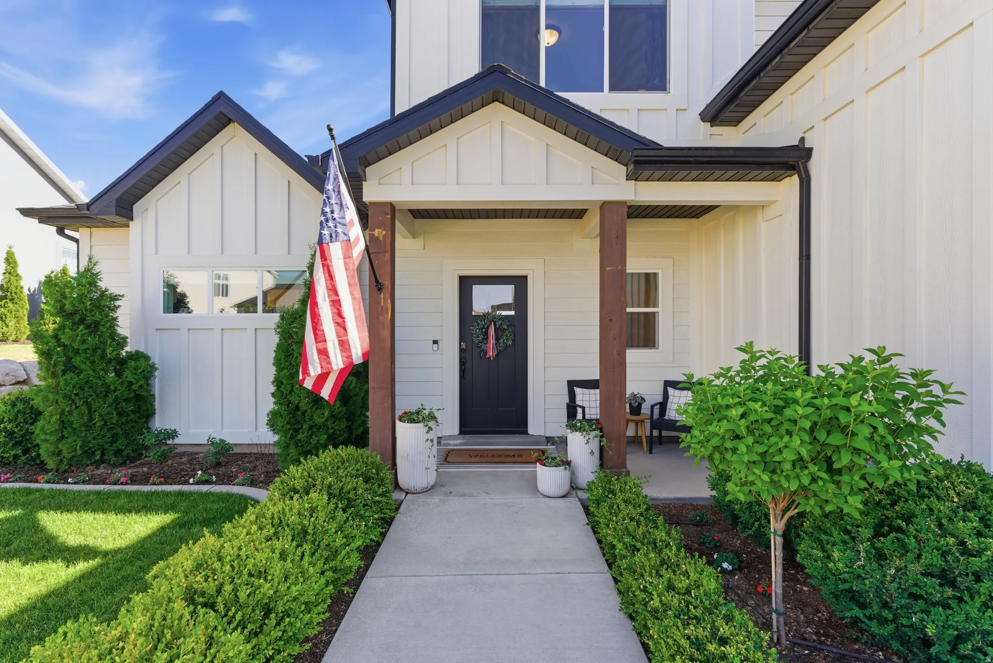 Modern farmhouse exterior with vertical board and batten siding, dark trim, and a covered porch