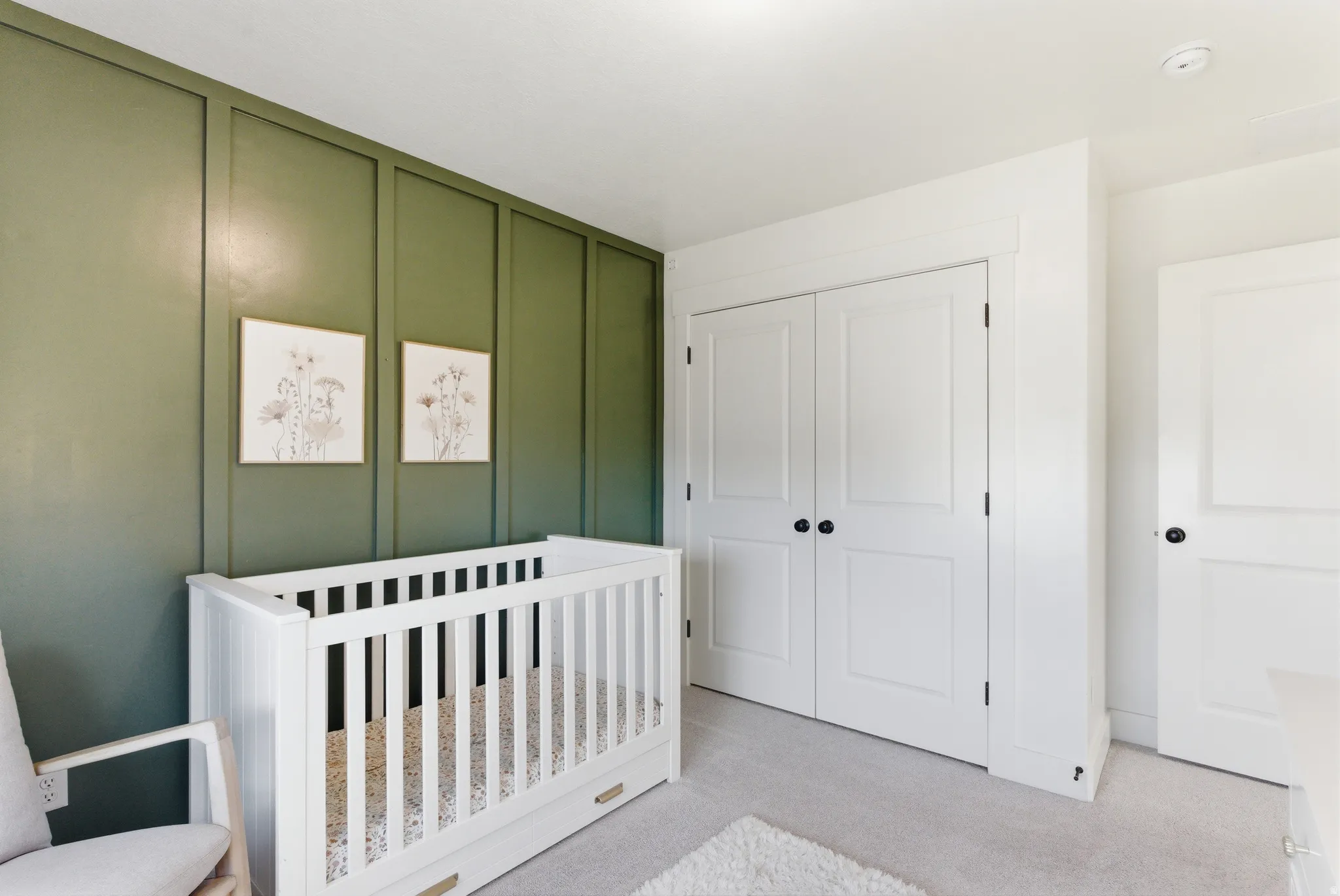 Room featuring a striking green accent wall with vertical paneling, providing a distinct architectural detail