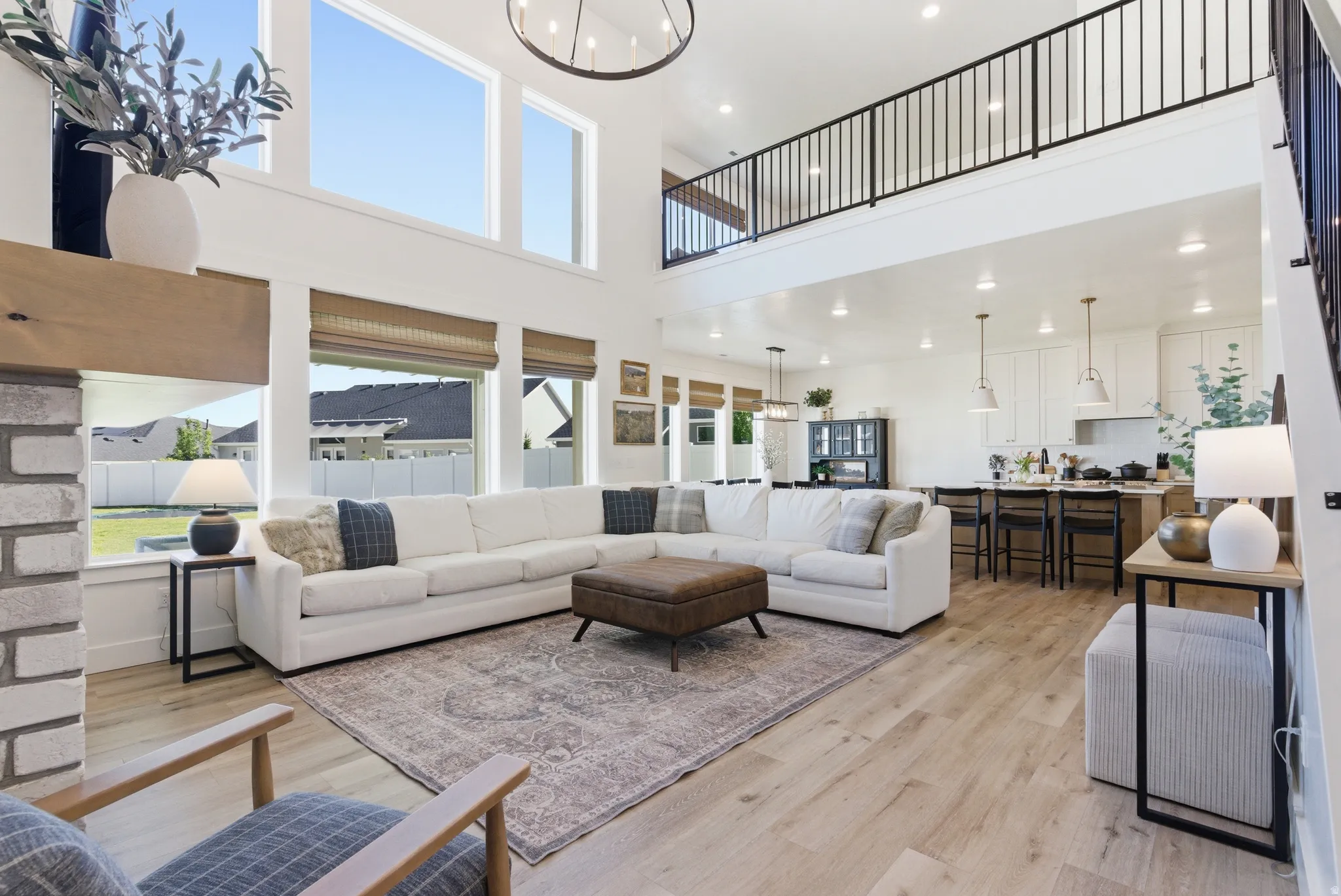 Vaulted great room featuring tall windows, wood-finish flooring, and an open-concept design