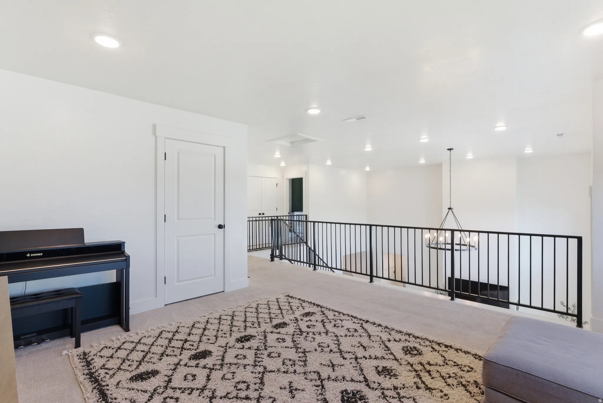 Spacious loft area featuring light-toned carpeting and recessed lighting