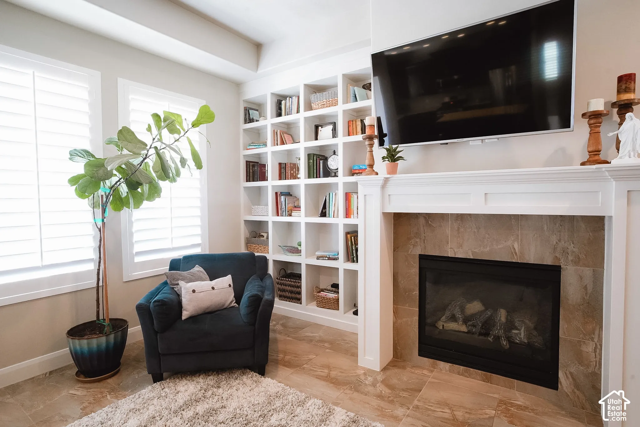 Built-in fireplace with a tiled surround, white mantel, and integrated television mount