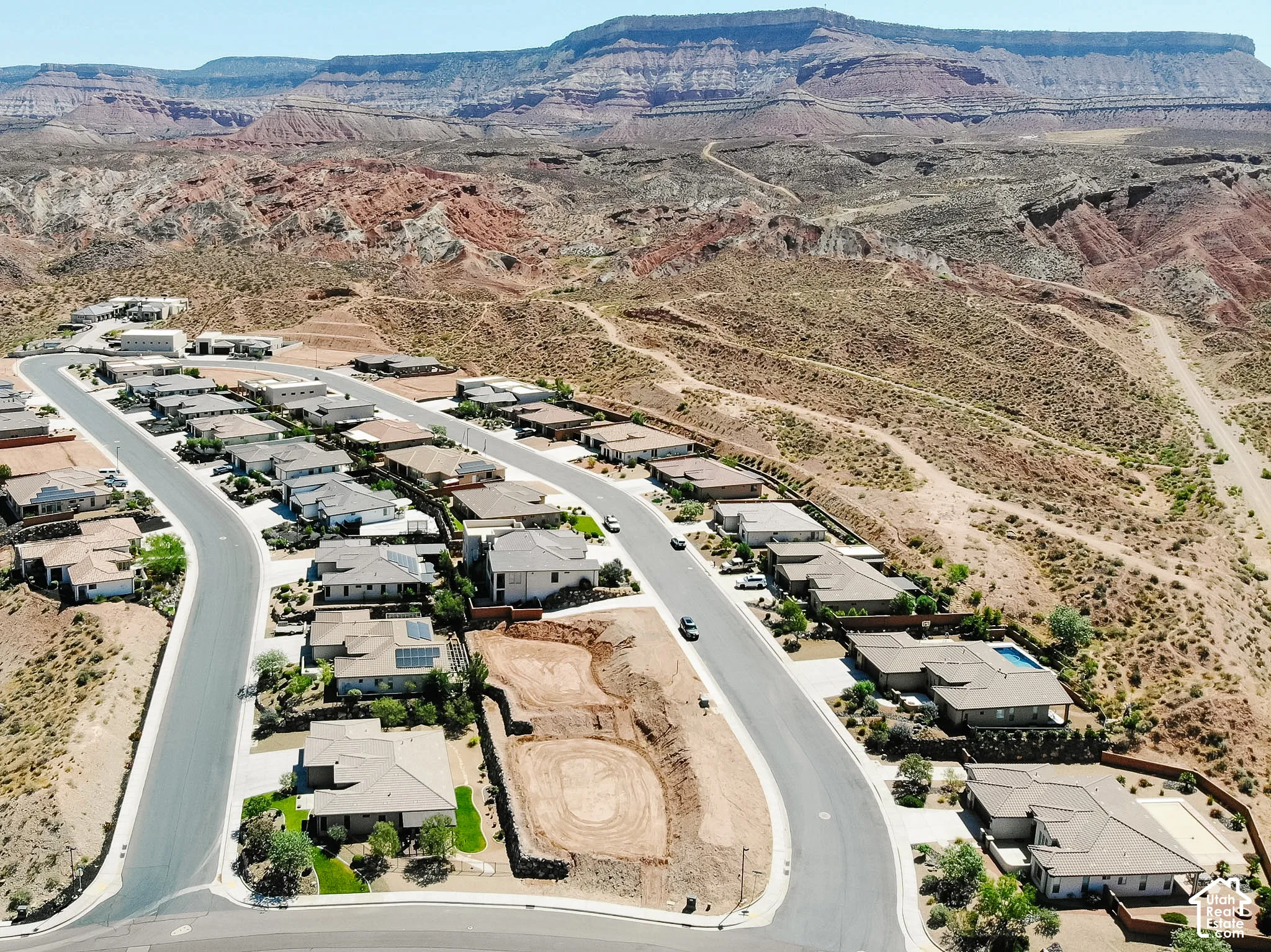 Residential development featuring single-story homes, paved streets, and a desert landscape backdrop