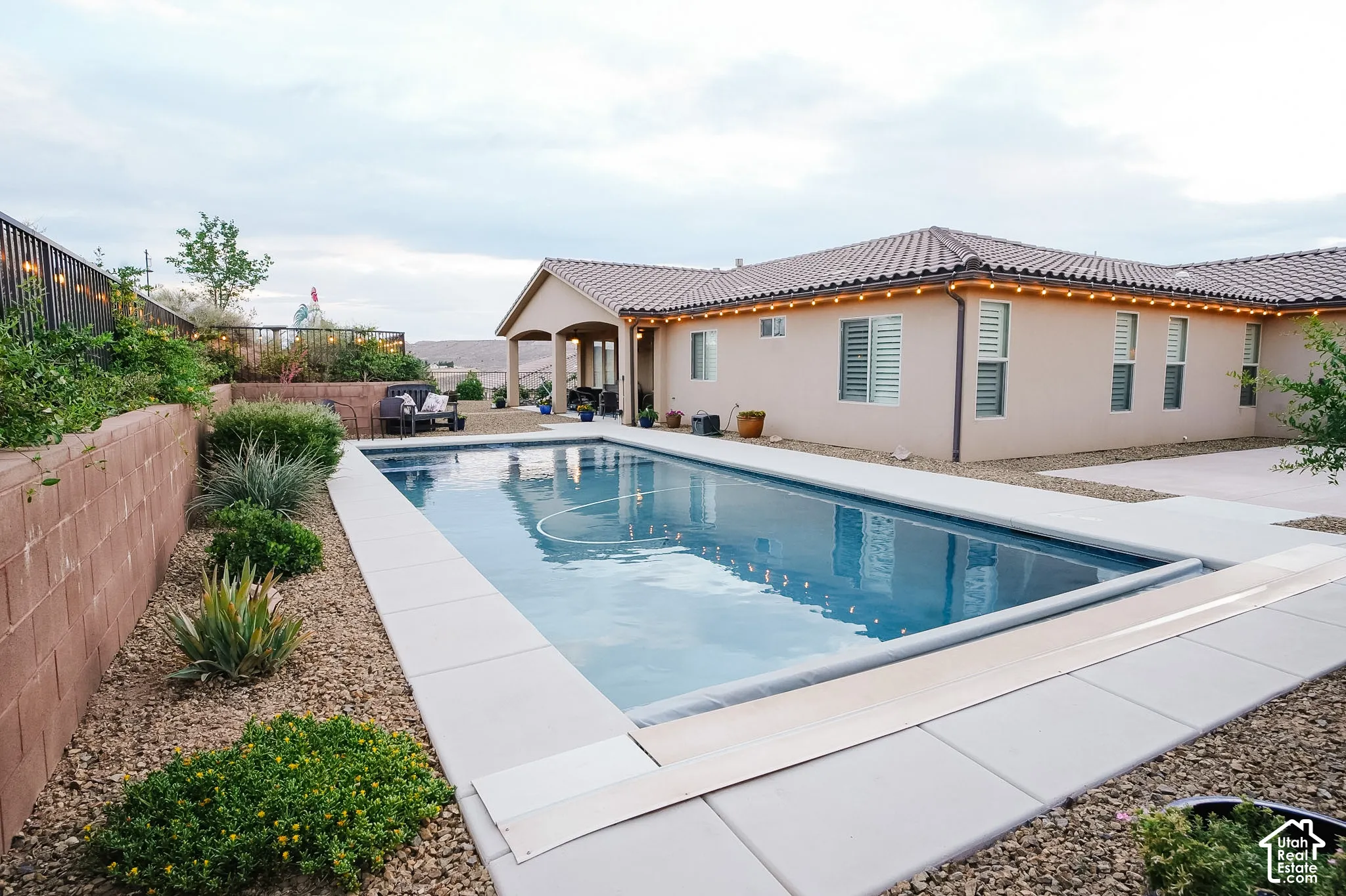 Rectangular swimming pool with an integrated cover, surrounded by concrete decking