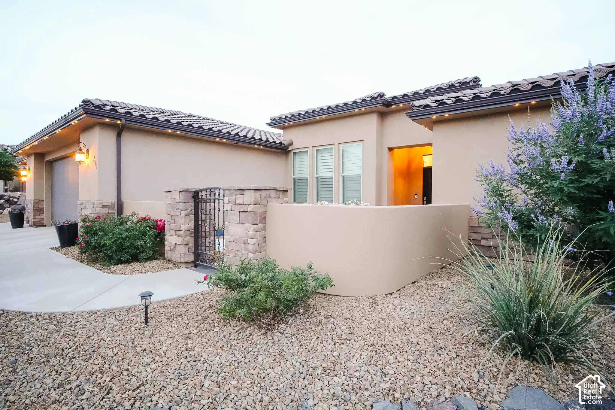 Stucco exterior featuring stone accents and a tiled roofline